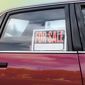 Image of a car with a "For Sale" sign posted on the back window