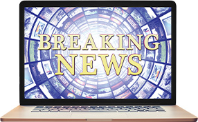 Image of a laptop showing text, "Breaking News"